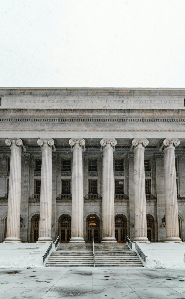 Majestic courthouse facade with columns and stairs blanketed in snow, capturing Denver's winter charm.